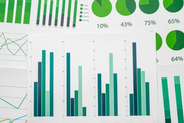 article banner featuring a bunch of paperes with green colored charts indicating performance