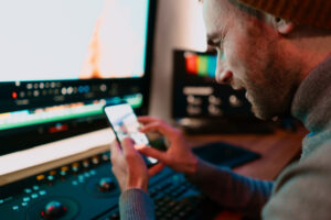 article banner featuring a male video editor working on his phone and computer.