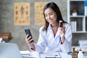 image in blog article featuring a female doctor holding a bottle of pills while having a video call with a patient