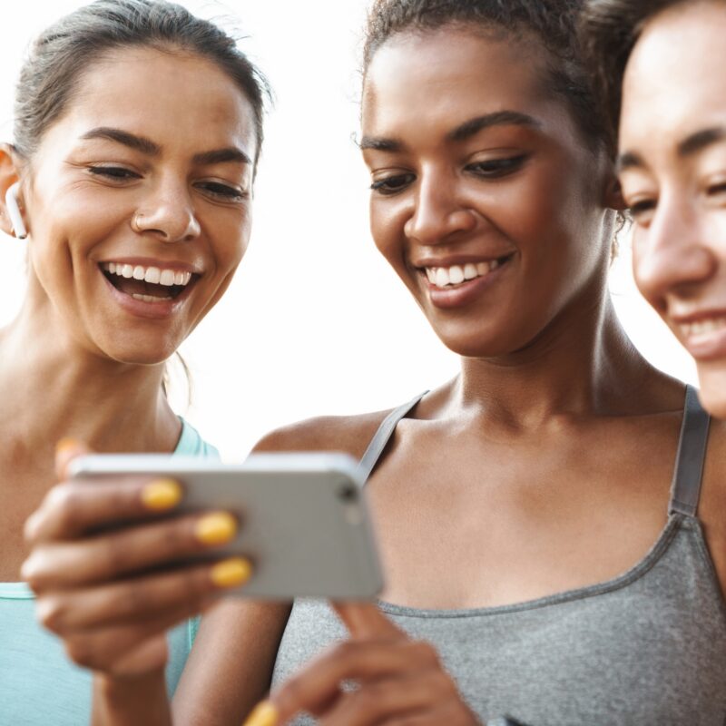 article banner image featuring three women in fitness wear looking at a smartphone