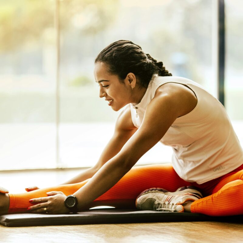 Wellness Marketing Services: Key Benefits to Consider article banner image featuring a woman stretching on a yoga mat