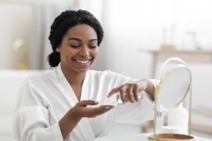 Understanding Women’s Health and Wellness Product Labels article featured banner featuring woman putting on moisturizer