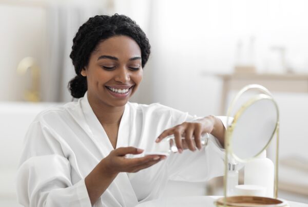 Understanding Women’s Health and Wellness Product Labels article featured banner featuring woman putting on moisturizer