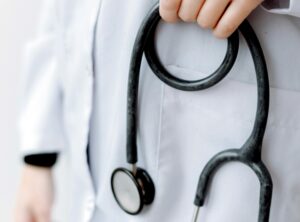 How Healthcare Brands Can Reach Patients in a Digital-First World article banner featuring close up shot of doctor holding stethoscope