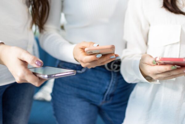 banner image featuring three women using social media on smartphone for the article How Social Media Shapes Women’s Health Conversations