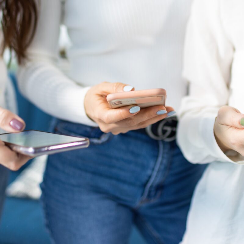 banner image featuring three women using social media on smartphone for the article How Social Media Shapes Women’s Health Conversations